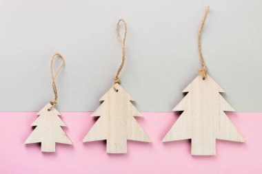 Noel ve yeni yıl gün festival dekorasyon, ahşap Noel ağaçları pembe ve gri arka plan üzerinde. Metin için yer kopyalayın. Düz yatıyordu. Yukarıdan görüntülemek.