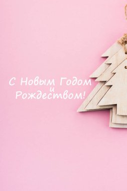 Noel ve yılbaşı şenlikli dekorasyon, pembe bir arka plan üzerinde ahşap Noel ağaçları. Metin için yer kopyalayın. Düz yatıyordu. Gelen yukarıdaki metin ile Happy New Year ve Merry Christmas (Rusça metin görüntülemek).