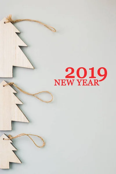 Christmas and New Year\'s Day festive decoration, wooden Christmas tree on gray background.  Copy space for text. Flat lay. View from above with text 2019 New Year.