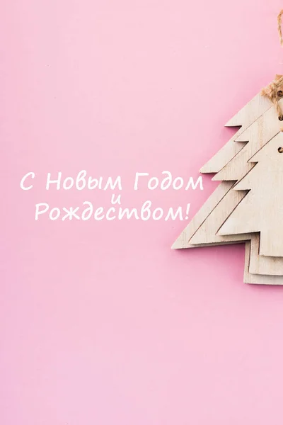 クリスマスとお正月のお祭り装飾 ピンクの背景の木のクリスマス ツリー テキストのためのスペースにコピーします フラットが横たわっていた 新年あけましておめでとうございます メリー クリスマス ロシア語のテキストをテキストを上から表示します — ストック写真