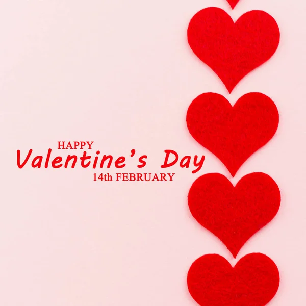 St.Valentine\'s Day holiday background. Red hearts in a shape of a heart on pink background. Flat lay. View from above with text Happy Valentine\'s Day and 14th February.