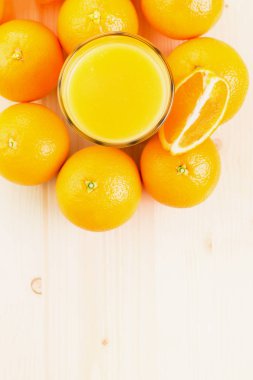 Bardak taze portakal suyu ile portakal preslenmiş ve turuncu bölümü ahşap arka plan üzerine dilimlenmiş. Sağlıklı yaşam konsepti. Yukarıdan görüntüleyin. Uzay fot metin kopyalama.