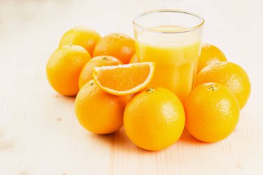 Bardak taze portakal suyu ile portakal preslenmiş ve turuncu ahşap arka plan üzerine dilimlenmiş. Sağlıklı yaşam konsepti. Metin için yer kopyalayın.