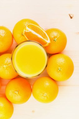 Bardak taze portakal suyu ile portakal preslenmiş ve turuncu bölümü ahşap arka plan üzerine dilimlenmiş. Sağlıklı yaşam konsepti. Yukarıdan görüntülemek.