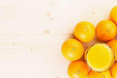 Bardak taze portakal suyu portakal ile ahşap arka plan üzerinde basılı. Sağlıklı yaşam konsepti. Yukarıdan görüntüleyin. Uzay fot metin kopyalama.