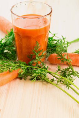 Taze havuç suyu ile havuç ve havuç tops ahşap masa arka plan üzerinde cam. Sağlıklı yaşam konsepti. Metin için yer kopyalayın.