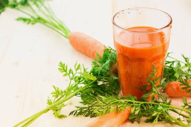 Taze havuç suyu ile havuç ve havuç tops ahşap masa arka plan üzerinde cam. Sağlıklı yaşam konsepti. Metin için yer kopyalayın.