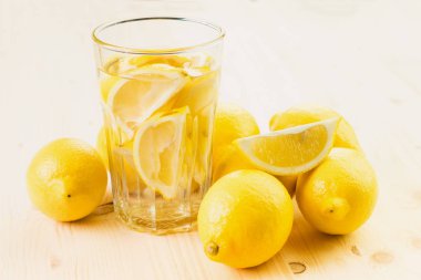 Bardak su ile limon parçası ya da taze el bardak limonata limon ile üzerinde ahşap arka plan yaptı. Metin için yer kopyalayın.