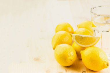 Bardak su ile limon parçası ya da taze el bardak limonata limon ile üzerinde ahşap arka plan yaptı. Metin için yer kopyalayın.
