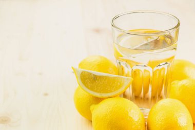 Bardak su ile limon parçası ya da taze el bardak limonata limon ile üzerinde ahşap arka plan yaptı. Metin için yer kopyalayın.