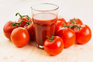 Bardak domates suyu ahşap zemin, sağlıklı yaşam konsepti üzerine domates ile.