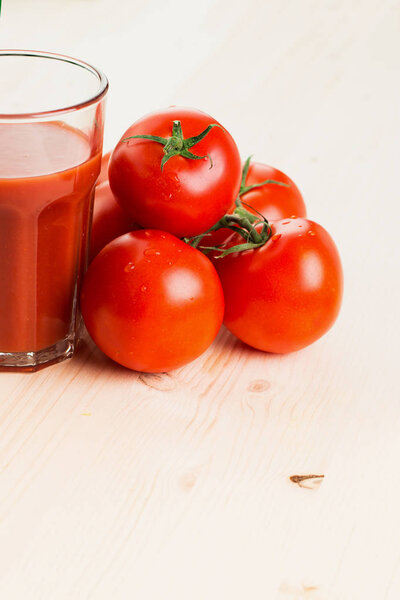 Glass of tomato juice with tomatoes on wooden background, Healthy lifestyle concept. Copy space for text.