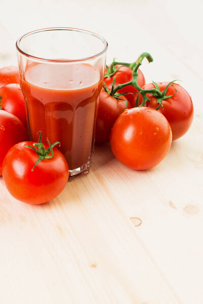 Glass of tomato juice with tomatoes on wooden background, Healthy lifestyle concept. Copy space for text.