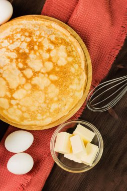 Ev yapımı taze gözlemeler malzemelerle: yumurta, tereyağı ve fırçalamak rustik ahşap zemin üzerinde. Üstten görünüm.