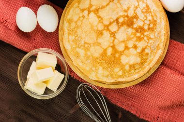 Ev yapımı taze gözlemeler malzemelerle: yumurta, tereyağı ve fırçalamak rustik ahşap zemin üzerinde. Üstten görünüm.