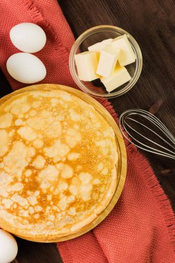 Ev yapımı taze gözlemeler malzemelerle: yumurta, tereyağı ve fırçalamak rustik ahşap zemin üzerinde. Üstten görünüm.