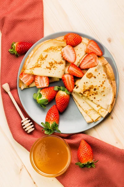 Ev yapımı taze gözlemeler çilek ve ballı ahşap arka plan üzerinde. Yukarıdan görüntüleyin. Metin için yer kopyalayın.