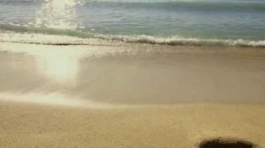 Deniz tarafı plaj altın kum ve hala yavaş yavaş kıyıda çökmesini dalgalar görünümünü. Güneşli bir gün. Yaz ve tatil kavramı.