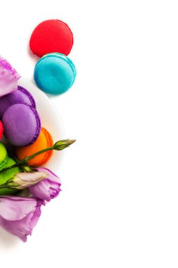 Pasta macaron veya izole beyaz, renkli Badem Çerezler, pastel renkler, Menekşe bahar çiçekleri beyaz plaka acıbadem kurabiyesi. Metin için yer kopyalayın. Üstten Görünüm.