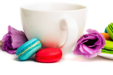 Pasta macaron veya izole beyaz, renkli Badem Çerezler, pastel renkler, Menekşe bahar çiçek kahve ile beyaz tabakta acıbadem kurabiyesi. Metin için yer kopyalayın. 