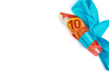 Doğum günü hediyesi gibi mavi kurdele ile haddelenmiş 10 euro banknot görünümünü. Beyaz arka plan üzerinde izole mevcut bir kavram olarak para. Metin için yer kopyalayın.