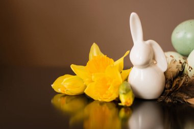 Küçük beyaz tavşan heykelcik Paskalya yumurtaları ve Nergis ile