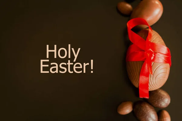 Duże i małe czekolada Wielkanoc eggsde dekorowane z czerwoną wstążką — Zdjęcie stockowe