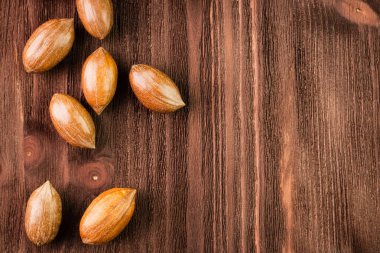 Pecan nuts in the shell on wooden background clipart