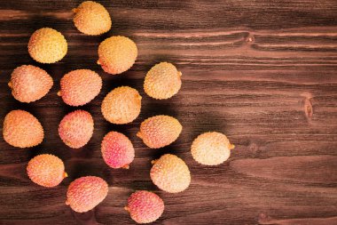Taze organik lychee meyve kahverengi ahşap zemin üzerinde. 