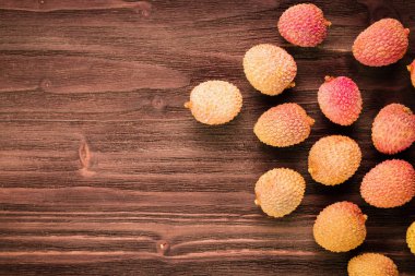 Taze organik lychee meyve kahverengi ahşap zemin üzerinde. 