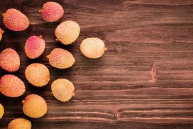 Taze organik lychee meyve kahverengi ahşap zemin üzerinde. 