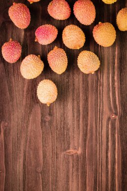 Taze organik lychee meyve kahverengi ahşap zemin üzerinde. 