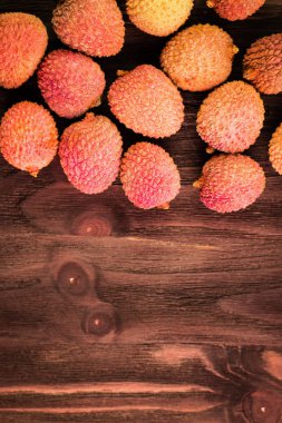 Taze organik lychee meyve kahverengi ahşap zemin üzerinde.