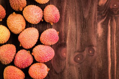 Taze organik lychee meyve kahverengi ahşap zemin üzerinde.