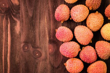 Taze organik lychee meyve kahverengi ahşap zemin üzerinde.