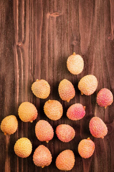 Fresh organic lychee fruits on brown wooden background. — Stock Photo, Image