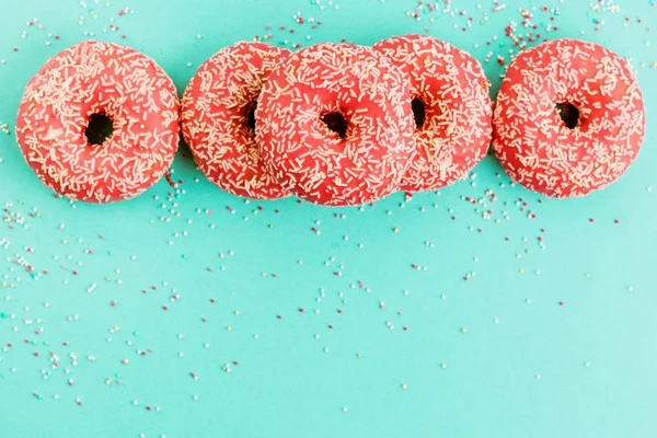 Donuts mit Sahnehäubchen auf blauem Hintergrund. — Stockfoto