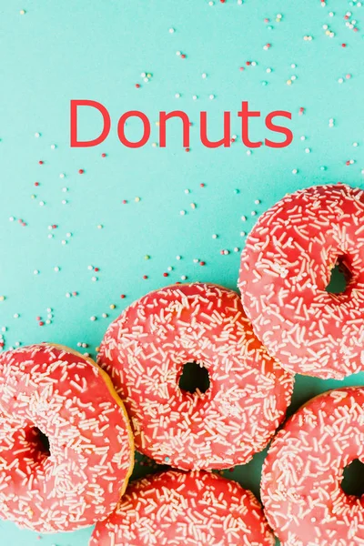 Donuts versierd met slagroom op blauwe achtergrond. — Stockfoto