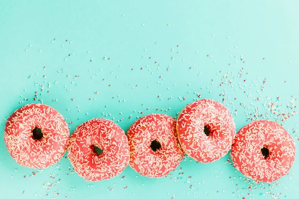 Donuts mit Sahnehäubchen auf blauem Hintergrund. — Stockfoto