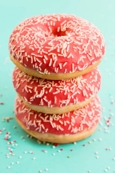 Donuts decorated with icing on blue background. — Stock Photo, Image