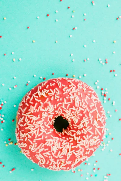 Donut decorado com cereja sobre fundo azul . — Fotografia de Stock