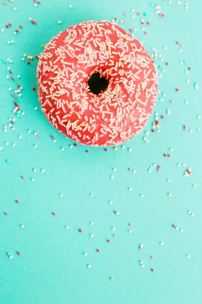 Donut decorado com cereja sobre fundo azul . — Fotografia de Stock