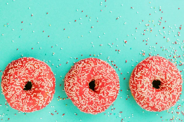 Donuts decorados com gelo sobre fundo azul . — Fotografia de Stock