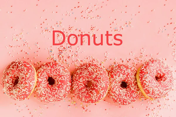 Cinco donuts de coral. Donuts com cobertura em fundo rosa . — Fotografia de Stock