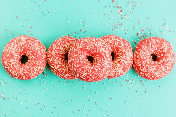 Donuts decorados com gelo sobre fundo azul . — Fotografia de Stock