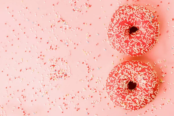 Zwei KorallenDonuts. Donuts mit Sahnehäubchen auf rosa Hintergrund. — Stockfoto