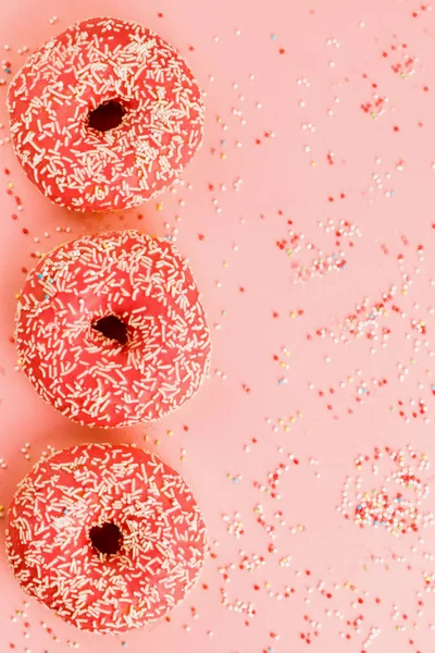 Three coral donuts. Donuts with icing on pink background. — Stock Photo, Image