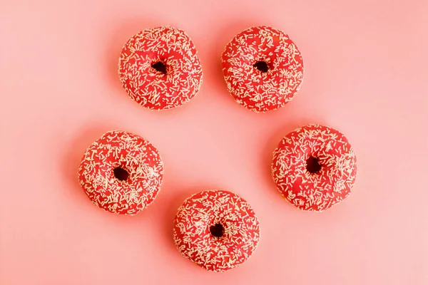 Fünf Korallen-Donuts. Donuts mit Sahnehäubchen auf rosa Hintergrund. — Stockfoto