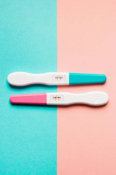 Positive pink and blue plastic pregnancy test on pink background — Stock Photo, Image