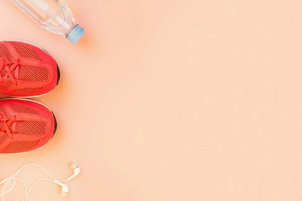 White headphones, a bottle of fresh water and pink sneakers — Stock Photo, Image